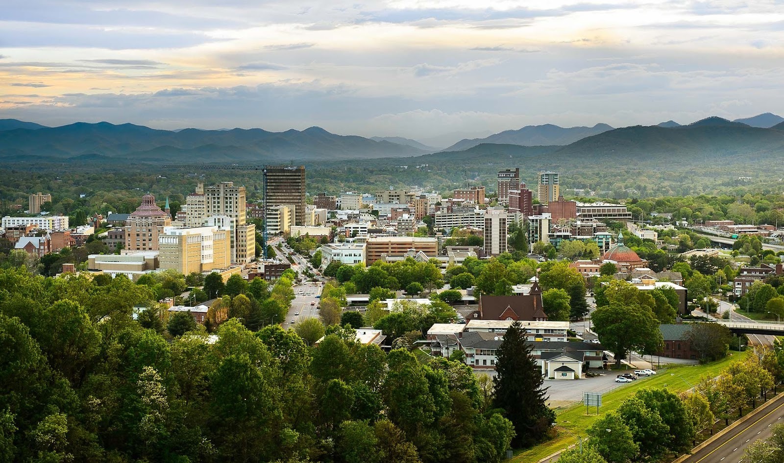 Cityscape of Asheville as the fog rises over the mountains.