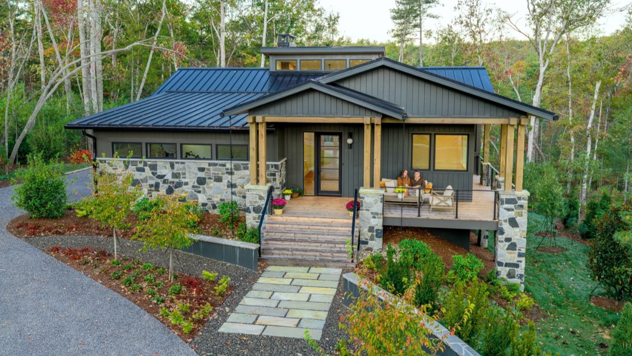 A grey and stone home is shown in The Ramble Biltmore Forest.